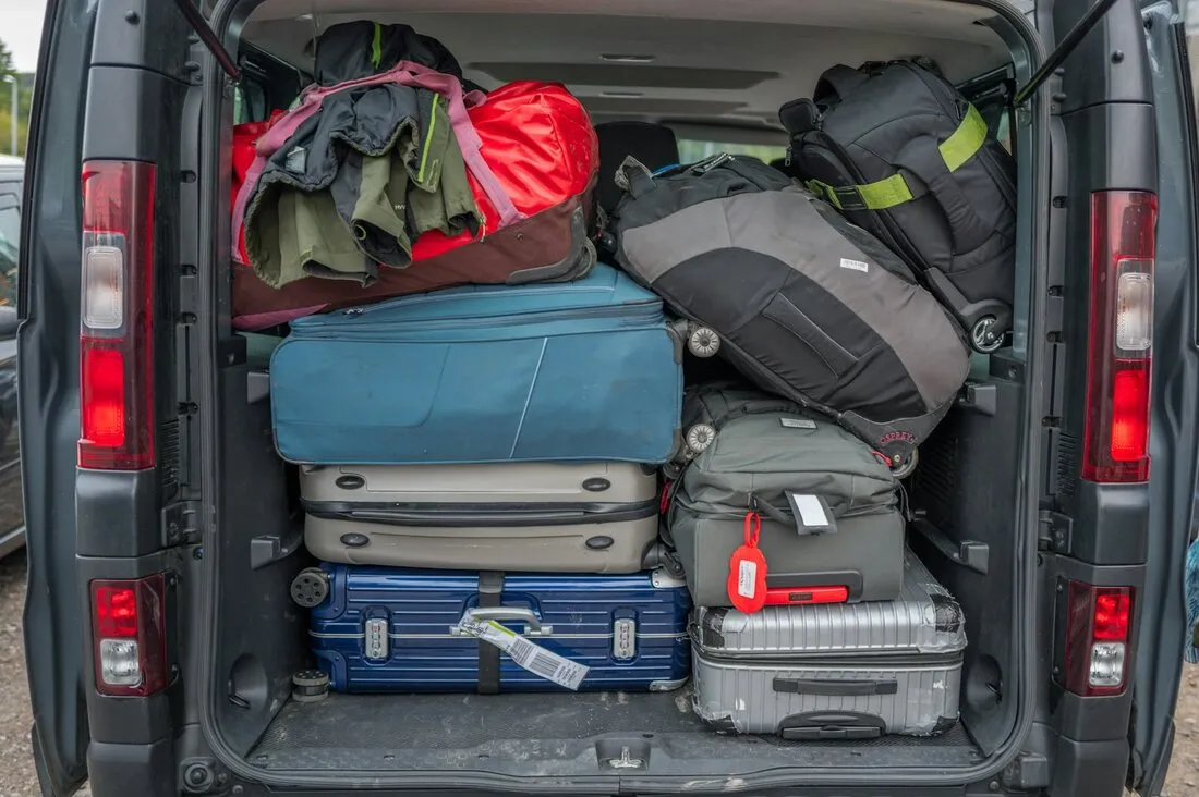 Portbagaj de microbuz încărcat cu valize și genți de voiaj